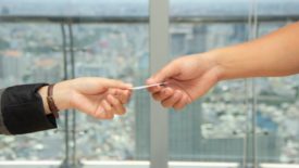 two hands exchanging a photo ID