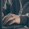 Person in hoodie on laptop